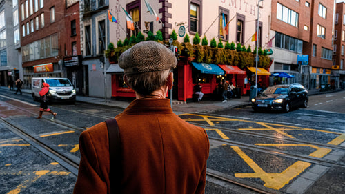 Person in a brown coat and hat walking on a Dublin city Capel street pubs restaurants 
