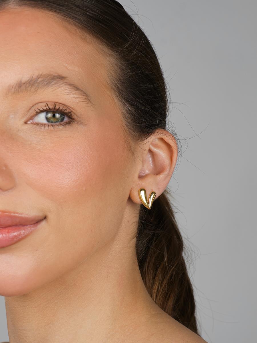 Petite gold heart charm layered with other necklaces - Dublin jewelry trend