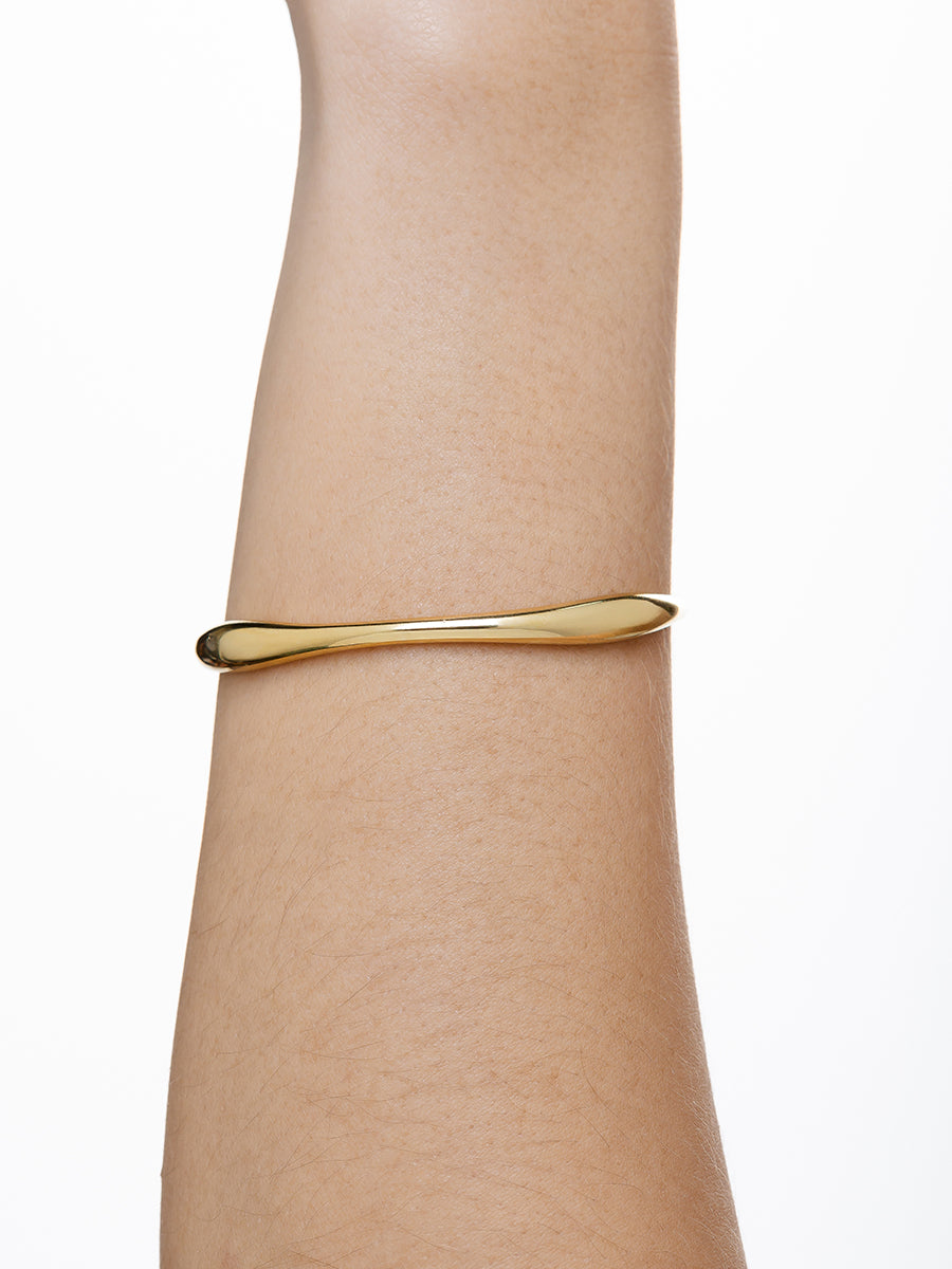 Gold wave bangle layered with bracelets - Dublin summer jewelry trend